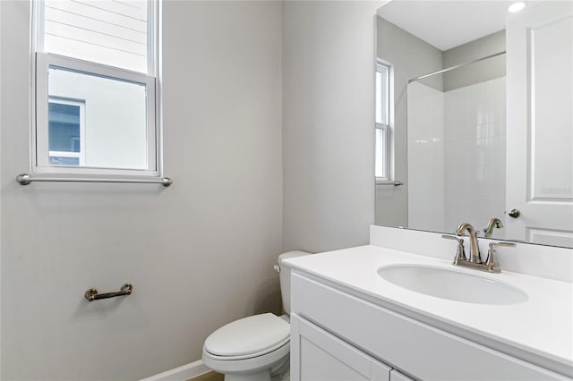 bathroom with vanity, a shower, and toilet