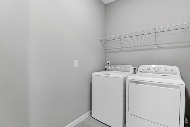 laundry room featuring washing machine and dryer and light tile patterned floors