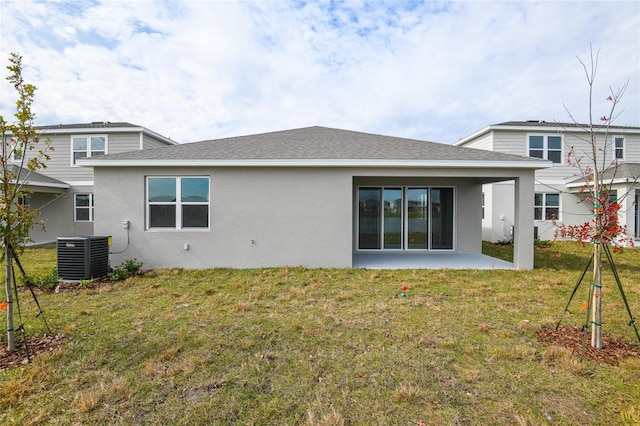 rear view of house with cooling unit, a yard, and a patio