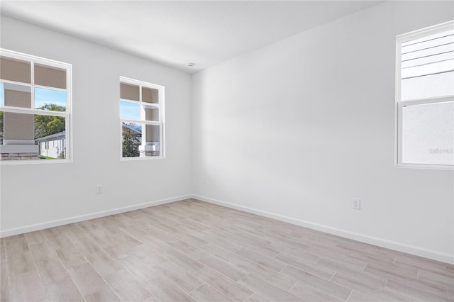 spare room with light wood finished floors and baseboards