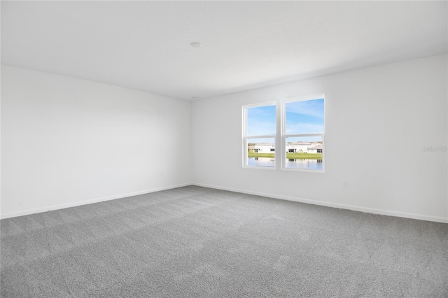 empty room featuring baseboards and carpet flooring