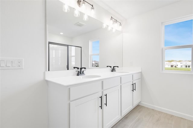 full bathroom featuring visible vents, a sink, baseboards, and double vanity