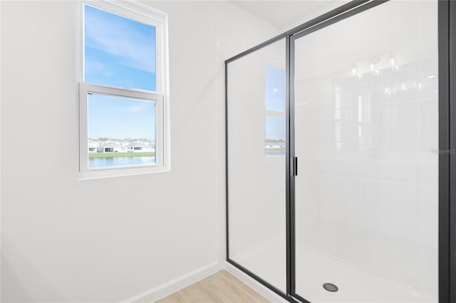 bathroom featuring a stall shower and baseboards