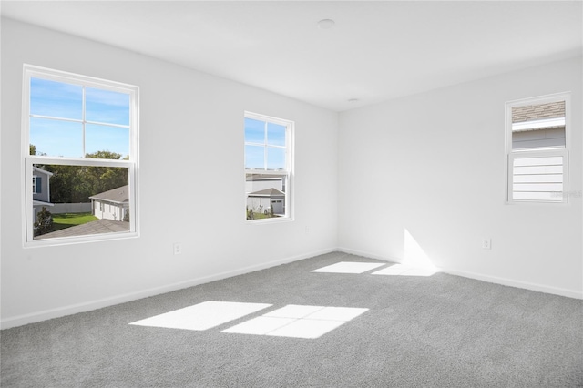 unfurnished room with carpet flooring and baseboards