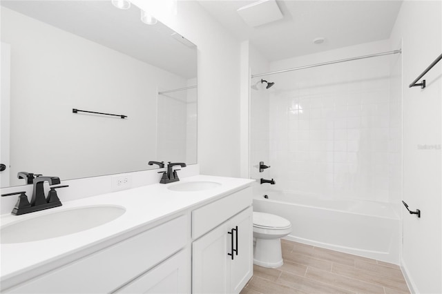 bathroom with shower / bathtub combination, a sink, toilet, and double vanity