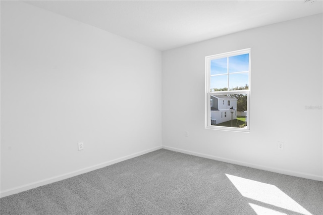 unfurnished room featuring carpet flooring and baseboards