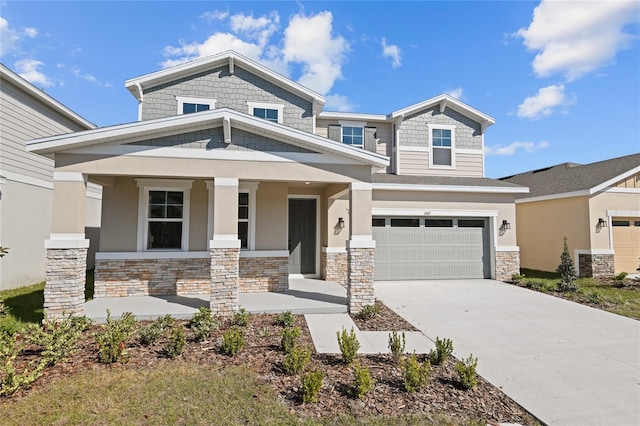 craftsman-style home featuring stone siding, covered porch, driveway, and stucco siding