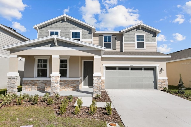 craftsman inspired home featuring a porch, stone siding, driveway, and a garage