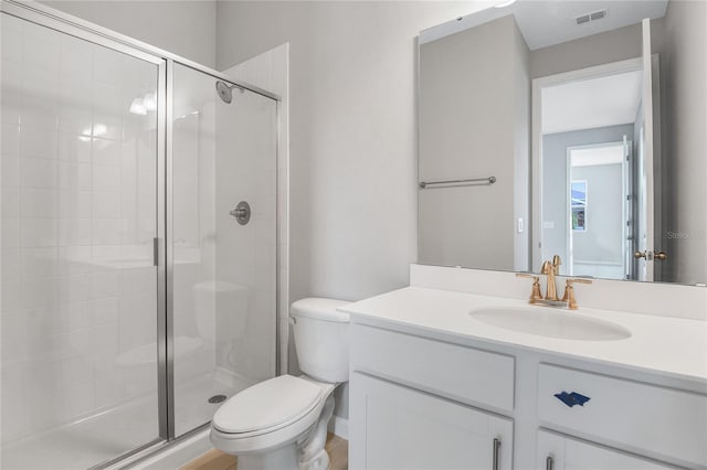 bathroom with walk in shower, vanity, and toilet