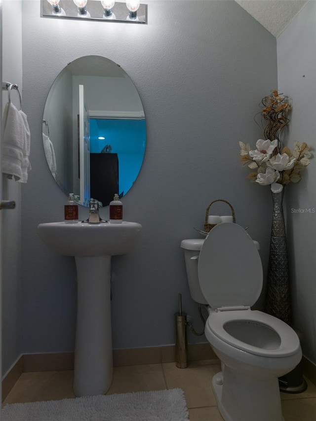 bathroom featuring tile patterned flooring, a textured ceiling, and toilet