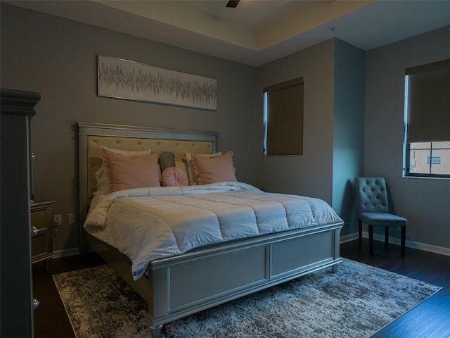 bedroom with dark hardwood / wood-style flooring and ceiling fan