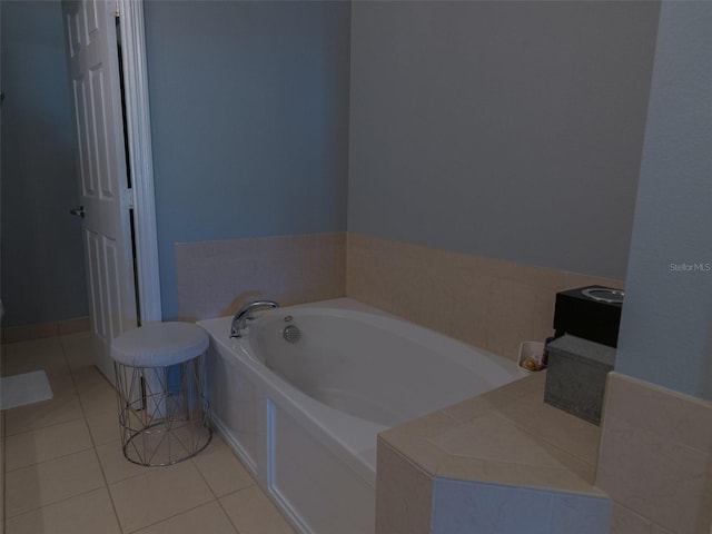 bathroom with tile patterned flooring and tiled bath