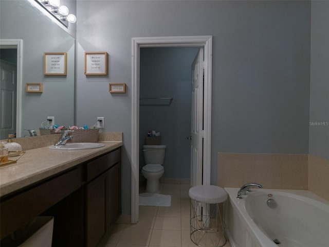 bathroom featuring tile patterned floors, vanity, toilet, and tiled bath