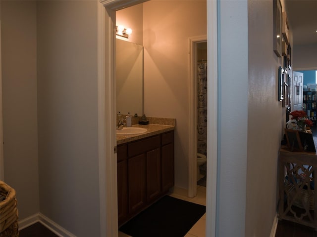 bathroom featuring tile patterned flooring, vanity, and toilet