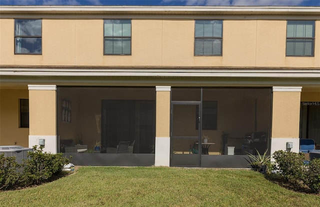 back of house with a lawn and a sunroom