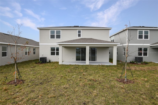 back of property with a yard, a patio, and central air condition unit