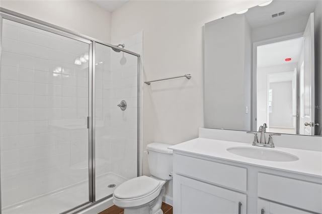 bathroom with vanity, an enclosed shower, and toilet