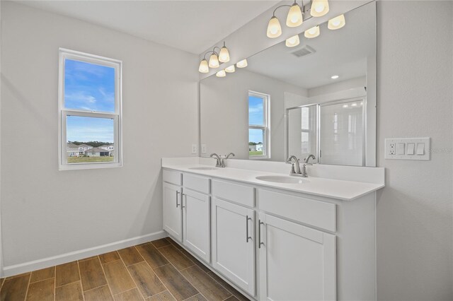 bathroom with vanity, a healthy amount of sunlight, and walk in shower