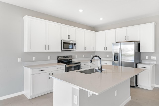 kitchen with sink, light tile patterned floors, white cabinetry, stainless steel appliances, and an island with sink