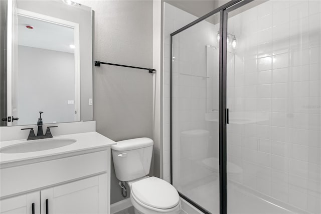 bathroom with vanity, toilet, and a shower with shower door