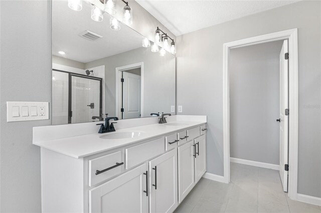 bathroom with vanity, a shower with shower door, and tile patterned floors