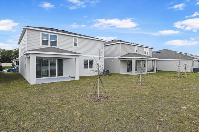 back of property with central AC, a lawn, and a patio