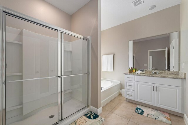 bathroom featuring tile patterned flooring, vanity, and plus walk in shower