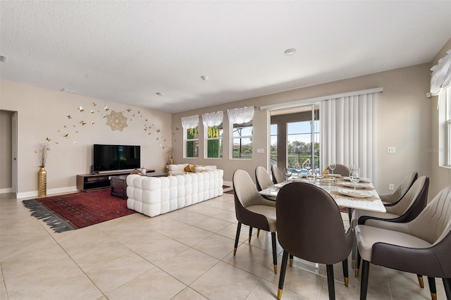 dining space with light tile patterned floors and a textured ceiling