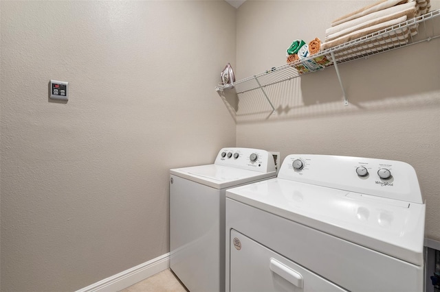 laundry room with independent washer and dryer and light tile patterned flooring