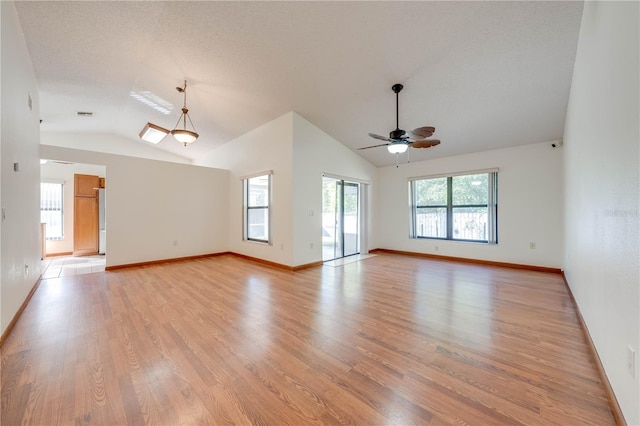 unfurnished room with a textured ceiling, light wood-type flooring, ceiling fan, and lofted ceiling