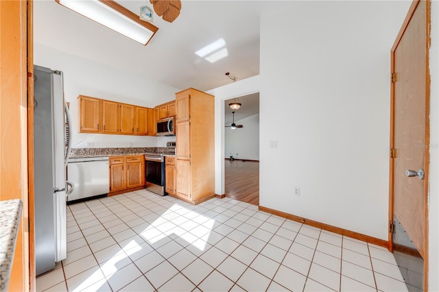 kitchen featuring ceiling fan, light tile patterned floors, hanging light fixtures, and appliances with stainless steel finishes