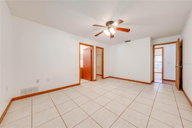 spare room with ceiling fan and light tile patterned flooring