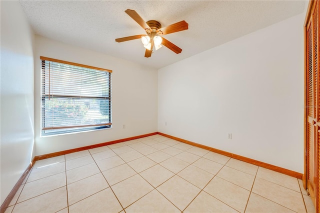 unfurnished room featuring light tile patterned floors, a textured ceiling, and ceiling fan