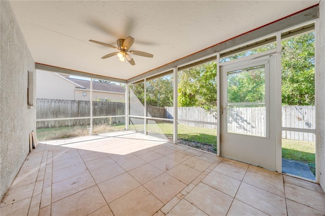 unfurnished sunroom featuring ceiling fan