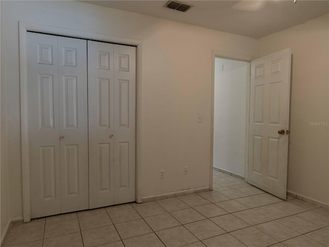 unfurnished bedroom with ceiling fan, a closet, and light tile patterned flooring