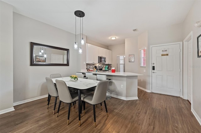 dining area featuring dark wood-type flooring