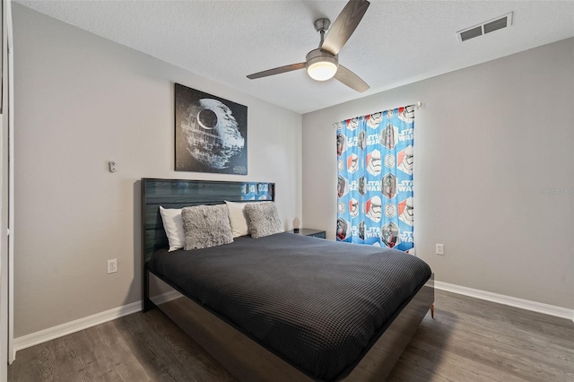 bedroom featuring ceiling fan, wood-type flooring, and a textured ceiling