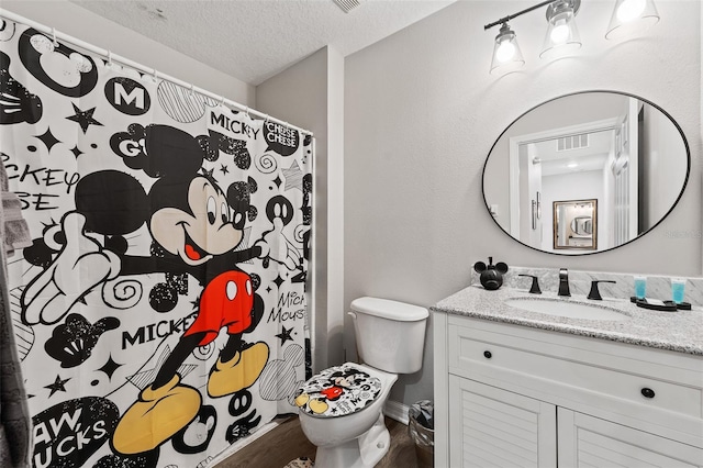 bathroom featuring hardwood / wood-style flooring, vanity, a textured ceiling, and toilet