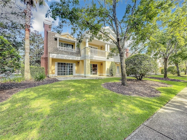 view of front of home featuring a front yard and a balcony