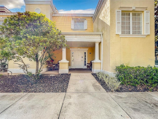 property entrance with stucco siding