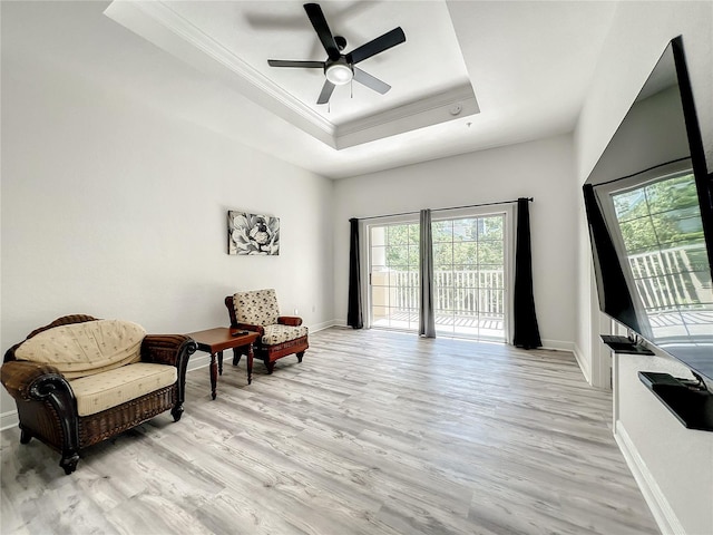 sitting room with a tray ceiling, ceiling fan, crown molding, and light hardwood / wood-style floors