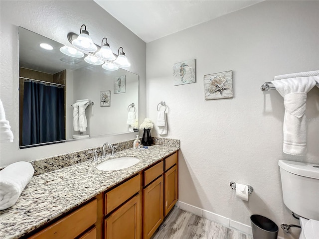 full bath with baseboards, toilet, wood finished floors, curtained shower, and vanity