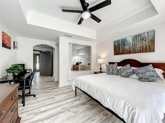 bedroom with ceiling fan, crown molding, light hardwood / wood-style flooring, and a tray ceiling