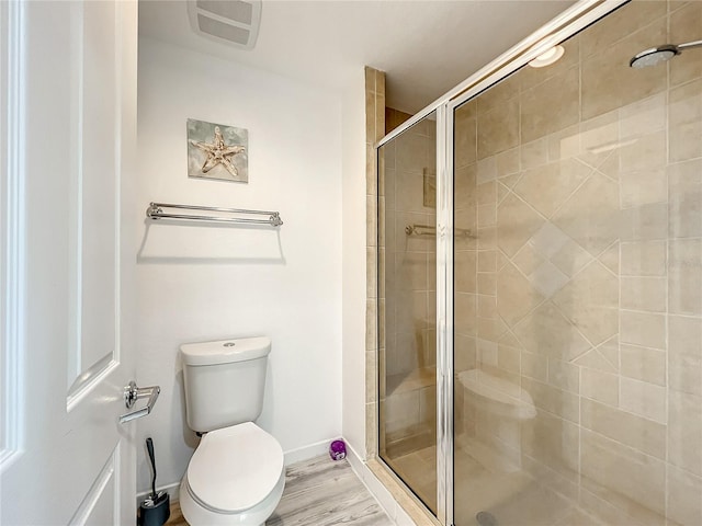 full bathroom featuring baseboards, visible vents, toilet, wood finished floors, and a shower stall