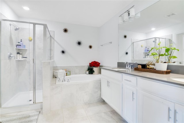 bathroom featuring plus walk in shower, vanity, and tile patterned floors