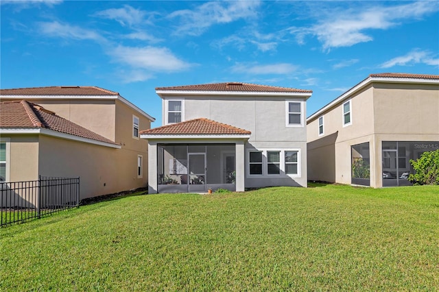 rear view of property with a sunroom and a yard