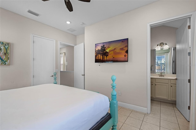 bedroom featuring ceiling fan, light tile patterned flooring, sink, and ensuite bath