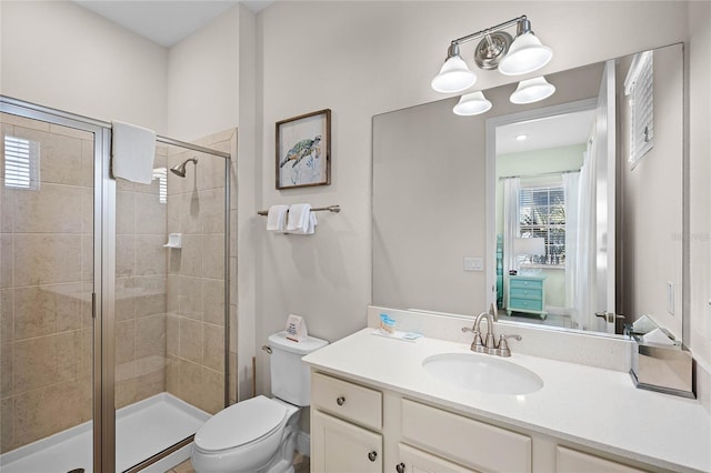 bathroom with vanity, toilet, and a shower with door