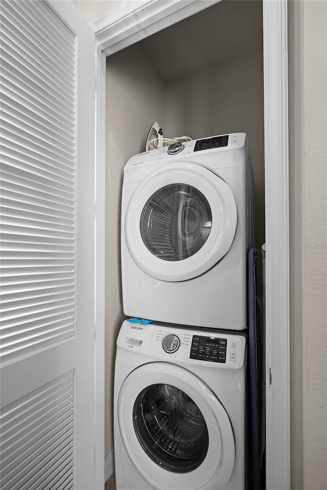 washroom featuring stacked washing maching and dryer