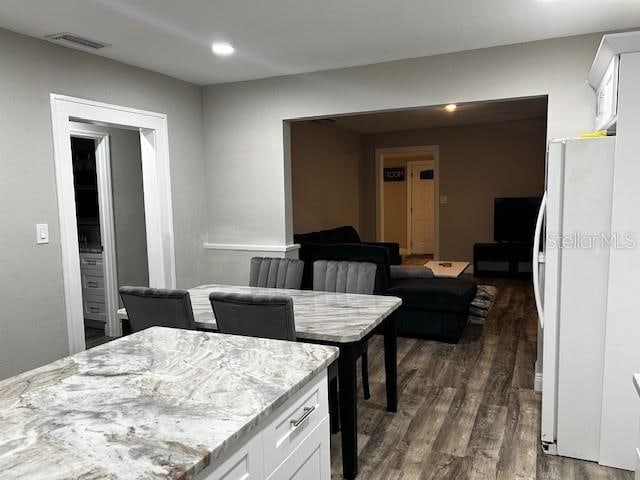 kitchen featuring white cabinets, light stone countertops, white fridge, and dark hardwood / wood-style floors